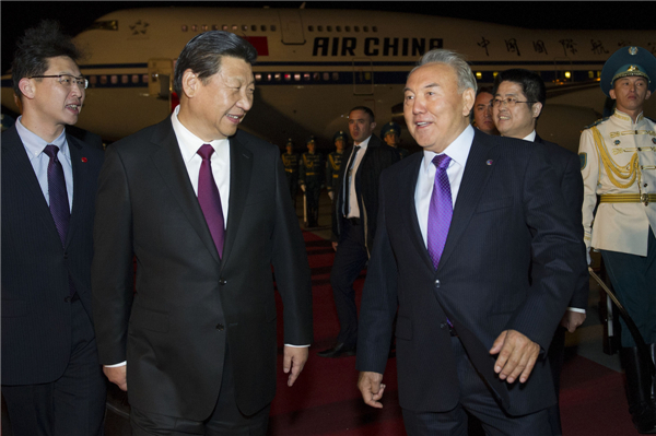 Chinese President Xi Jinping talks with his Kazakh counterpart Nursultan Nazarbayev after he arrived at Astana International Airport for a state visit to Kazakhstan, Sept 6, 2013.[Photo/Xinhua]
